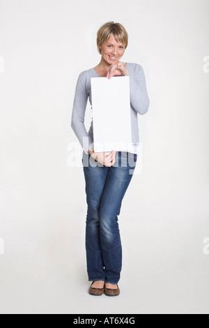 Young woman holding blank placard, portrait Stock Photo