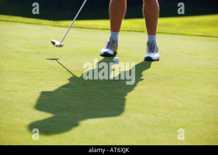 Austria, Male golfer preparing to drive ball, low section Stock Photo