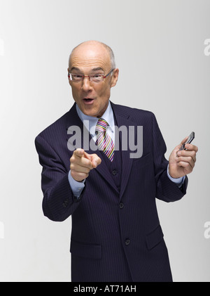 Businessman holding mobile phone, pointing Stock Photo