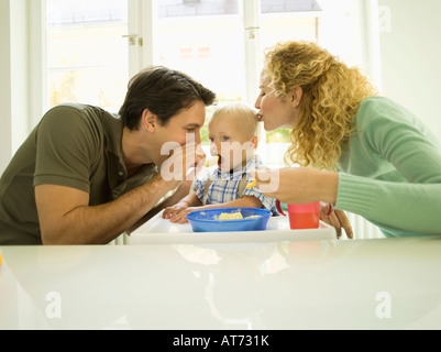 Young family, father feeding baby boy, (12-24 months) Stock Photo