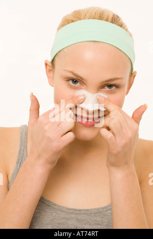 Woman applying adhesive plaster over nose, portrait Stock Photo