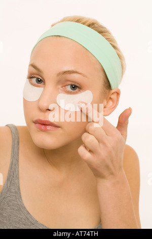 Woman applying adhesive plaster over nose, portrait Stock Photo