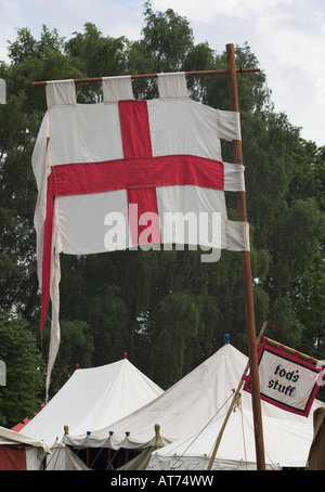 The English flag (cross of St. George) flying over a medieval fair. Tatton Park, Cheshire, United Kingdom. Stock Photo