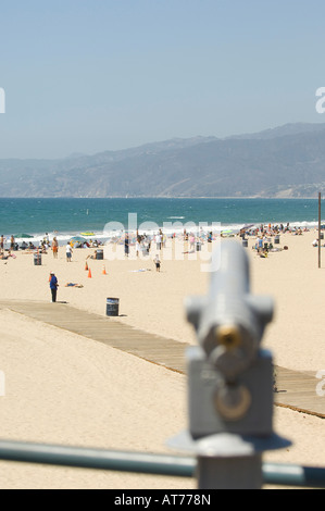 Telescope overlooking boardwalk and sunbathers enjoying a Southern California coastline. Stock Photo