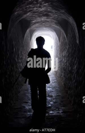 A man walks down a hall in Elmina Castle on a tour of the former slave fort Stock Photo