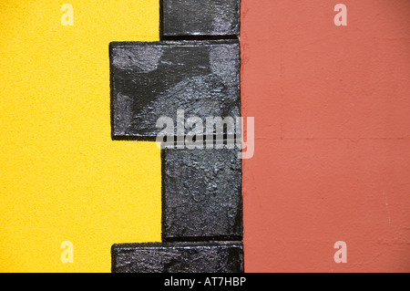 Painted wall red and yellow divided by black Stock Photo
