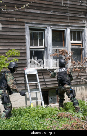 SWAT team members moving towards house to break window and deploy a ...