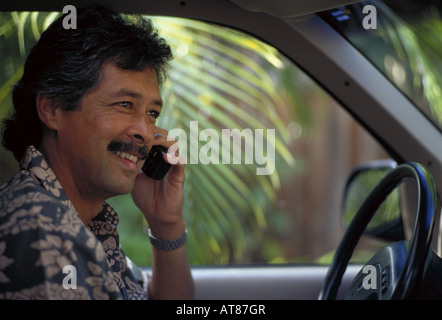 Honolulu businessman talking on cellular phone while stting in his car. Stock Photo