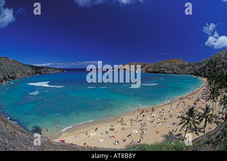 Perfect tropical day at Hanauma Bay with sunbathers and snorkelers enjoying the clear blue water and white sand crescent beach. Stock Photo