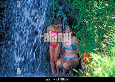 Mother and daughter under waterfall. Hanalei, Princeville, Kauai Stock Photo