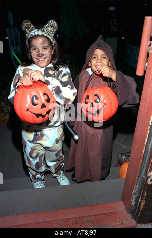 Siblings age 6 and 8 dressed as cat and monk for Halloween night out. St Paul Minnesota USA Stock Photo