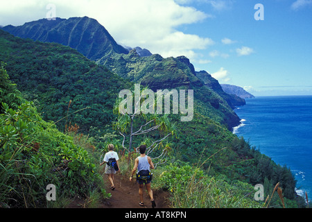 Couple sees views of the Na Pali Coast along the Kalalau Trail, Kauai Stock Photo