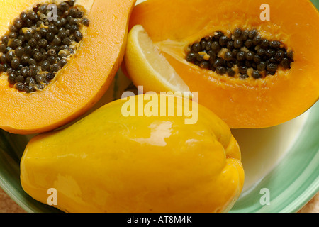 Plate of ripe papaya fruit with lemon wedge Stock Photo
