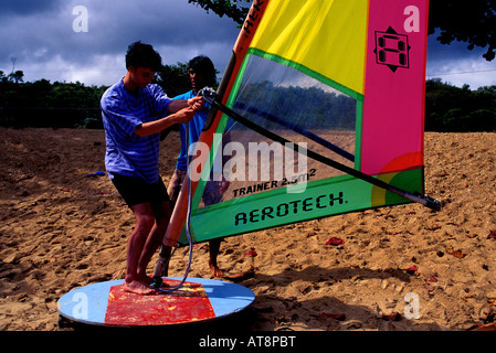 A man learns the technique of windsurfing on the sand of Anini Beach by an instructor of the Celeste Harvel Windsurf School. Stock Photo