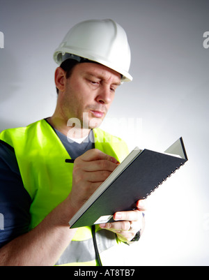 Construction worker or surveyor writing into a notebook Stock Photo