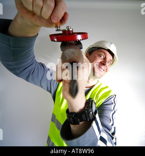 Construction worker with drill in threatening position Stock Photo