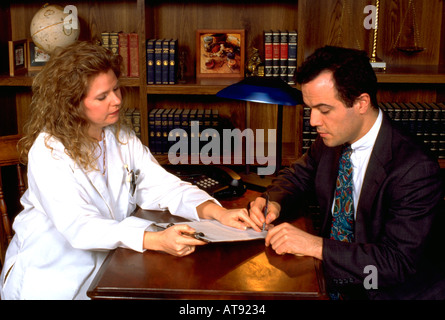 Woman Physician with Argentinean Hispanic patient ages 32 and 33 signature in office. St Paul Minnesota MN USA Stock Photo