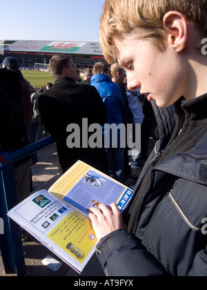 a boy reading a football programme inside Ninian Park Cardiff Stock Photo