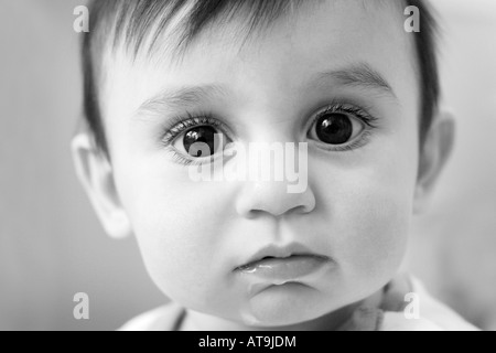 close up black and white of baby with big eyes drooling Stock Photo