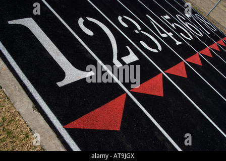 White numbers on the black surface of an athletic running track. Stock Photo