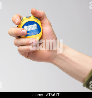 mans hand holding a yellow stop watch Stock Photo