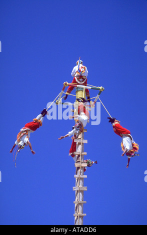 Five men participating in an Indian ritual in Mexico The flyers on the pole are suspended from their feet by ropes Stock Photo