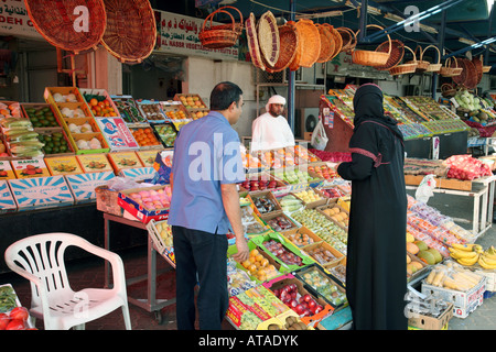 An arab couple buy fruit and veg at the market, Abu Dhabi city, UAE Stock Photo