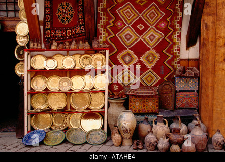 Moroccan vendor, rugs, ceramics, brass plates, shop, medina, Fes el-Bali, city of Fez, Morocco Stock Photo