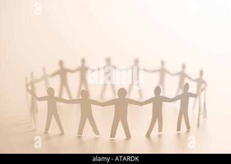 Cutout paper people standing in circle holding hands Stock Photo