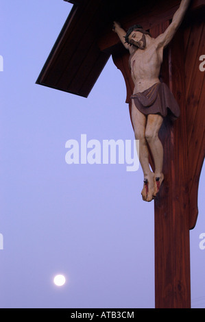 Figure of crucified Jesus Christ at full moon Stock Photo