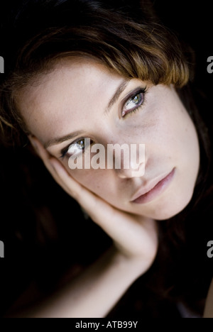 portrait of a nice dark-haired women with her head resting on hand Stock Photo