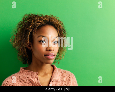 Head and shoulder portrait of young woman on green background Stock Photo