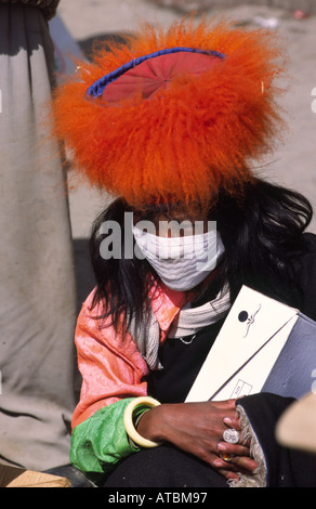 Khampa nomad girl in traditional clothes and a mouth cover against dust. Litang, Sichuan, China Stock Photo