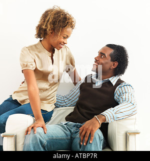 Portrait of smiling happy young couple sitting close together Stock Photo