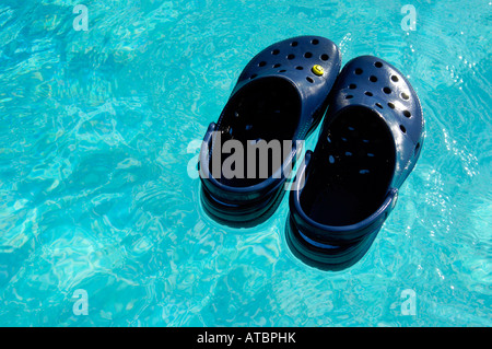 crocs blue beach footwear swimming pool floating shoes holiday vacation blue colour horizontal pair Stock Photo