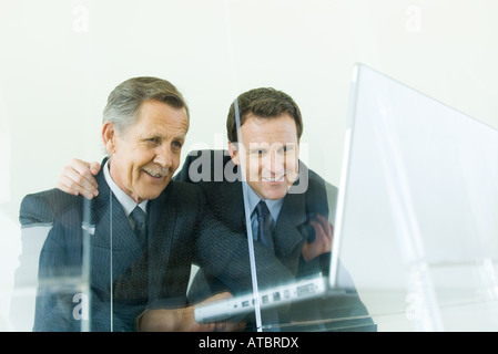 Two businessmen looking at laptop computer together, low angle view Stock Photo