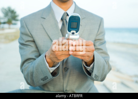 Businessman using cell phone outdoors, cropped view Stock Photo