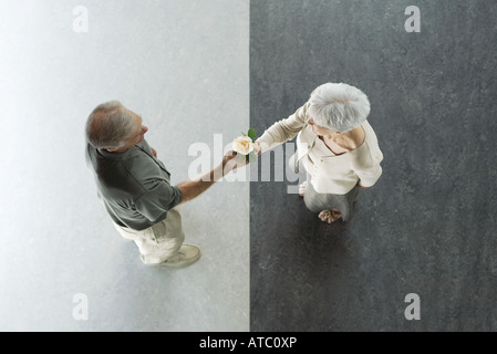Senior man giving his wife a rose, viewed from directly above Stock Photo