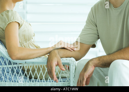 Couple sitting together, woman touching man's arm, cropped view Stock Photo