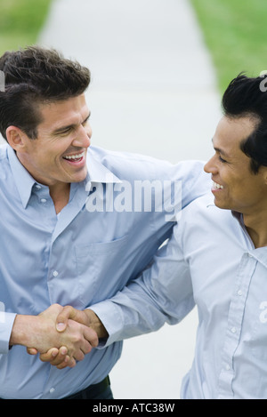 Two businessmen shaking hands, both smiling, high angle view Stock Photo