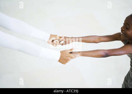 Little girl holding woman's hands, arms outstretched, cropped view Stock Photo