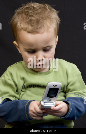 little cute, brown-haired boy with mobile Stock Photo