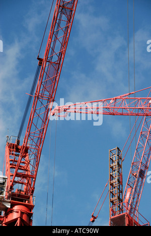 Red cranes against blue sky Stock Photo