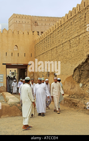 Omani s in traditional dishdasha dress leaving Ar Rustaq fort after prayers Oman Stock Photo