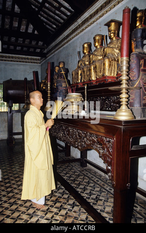 A Buddhist monk lights incense at the Giac Lam Pagoda the oldest in Ho Chi Minh City Stock Photo