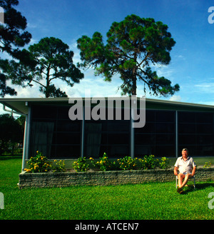 retired senior sits on lawn chair in front of his mobile home in Florida Stock Photo