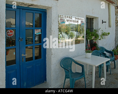 greek kafenion bar restaurant with a mirror on the wall reflecting the view of the sea and a bar on the shore in Horto Stock Photo