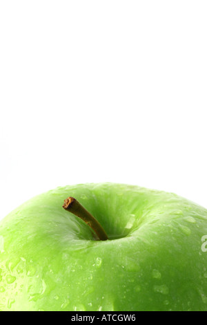 Cropped section of a fresh green granny smith apple with water droplets on a white background with copy space Stock Photo