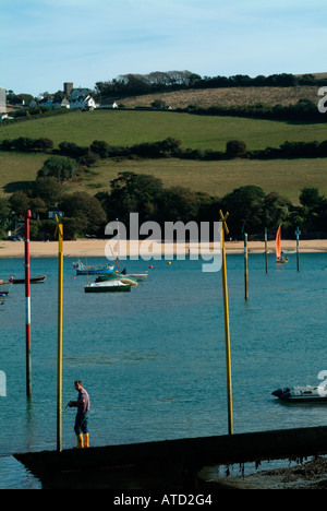 Sailing boats and a man on the slipway in the bay at Salcombe, Devon, England, UK. Stock Photo