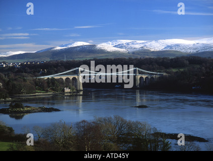 Menai Suspension Bridge Snowdonia in snow in background Anglesey North Wales UK Stock Photo